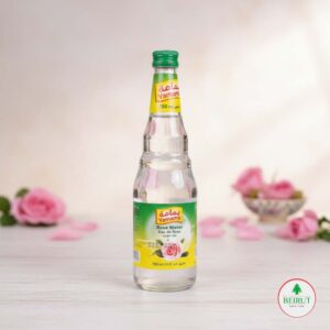 Botella de vidrio de Agua de Rosas Yamama 750ml con tapa verde, en fondo claro con pétalos de rosa. Producto de cocina árabe y cosmética natural.