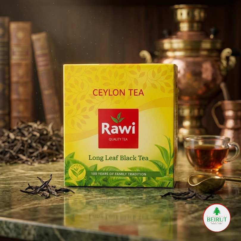 Caja de Té Negro de Ceilán marca Rawi en color amarillo con logo rojo, situada sobre una mesa de mármol verde con hojas de té sueltas