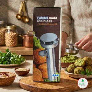 Caja de molde para falafel en acero inoxidable con texto en inglés y árabe. En la imagen se aprecia el utensilio metálico siendo usado para formar falafels