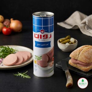Una lata de carne de pollo Zwan Chicken Luncheon Meat situada en el centro de una mesa. A la derecha, un sándwich de pan rústico