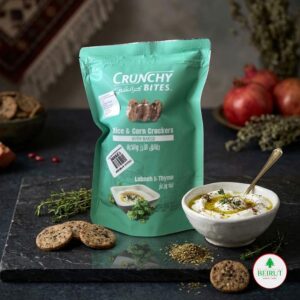 Bolsa de Crunchy Bites sabor Labneh y Tomillo, junto a un bowl de crema Labneh con aceite de oliva y especias sobre una tabla de piedra oscura.