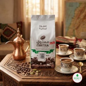 Empaque de café libanés Maatouk de 200 gramos sobre una mesa de madera labrada, acompañado de granos de café