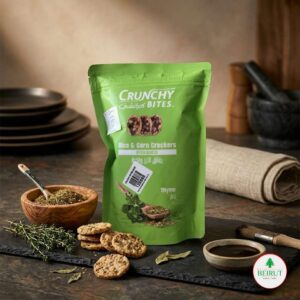 Bolsa Doypack verde de Crunchy Bites sabor tomillo, junto a especias en un cuenco de madera y galletas esparcidas sobre una base de piedra oscura.