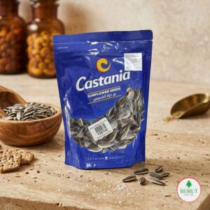 Empaque azul de semillas de girasol Castania de 150g sobre una tabla de piedra con semillas sueltas y galletas integrales.