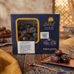 Caja azul de Dátiles Safawi Al Zawak de 400g con ventana transparente sobre mesa de madera y bandeja de cobre.