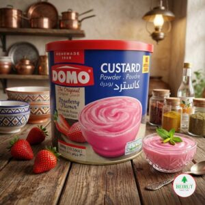 Una lata azul y roja de polvo para natilla marca Domo sabor fresa, situada sobre una mesa de madera rústica.